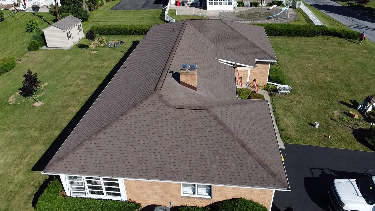 Aerial Sideview of a New Shingle Roof on a Brick Ranch House with Shed in the Back