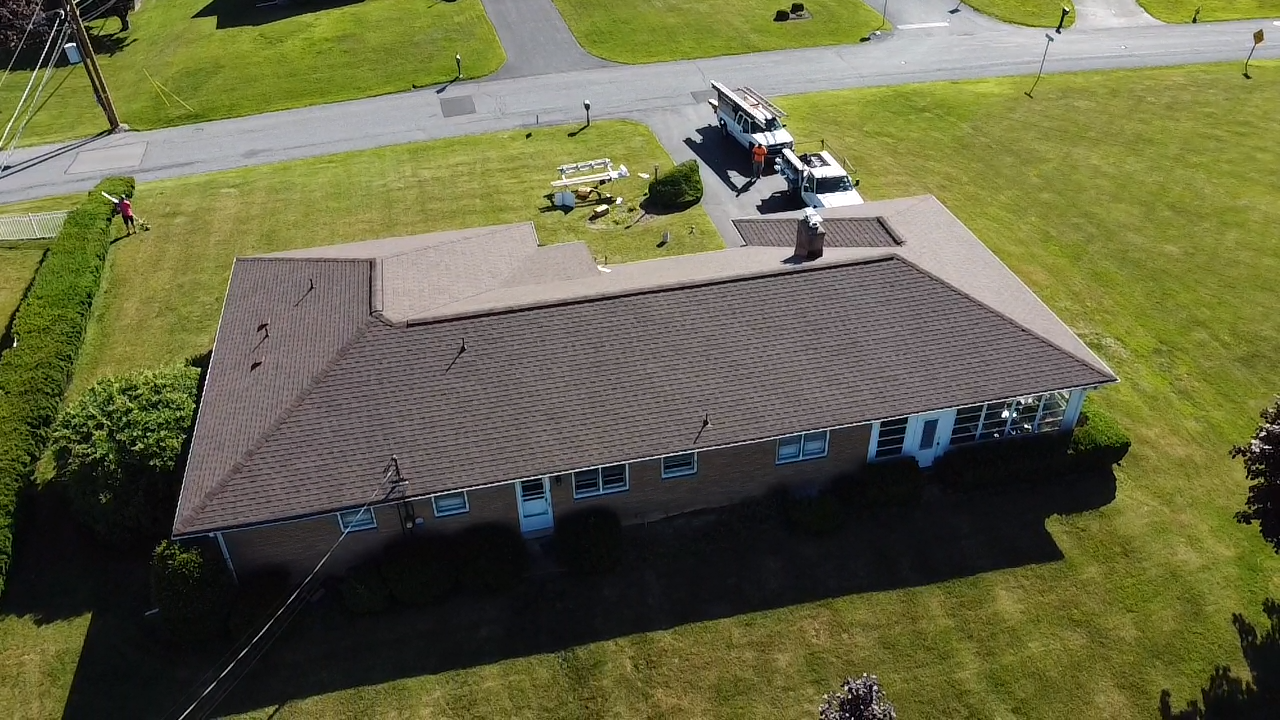 Rear Aerial View of a Brick Ranch House with A New Brown Shingle Roof