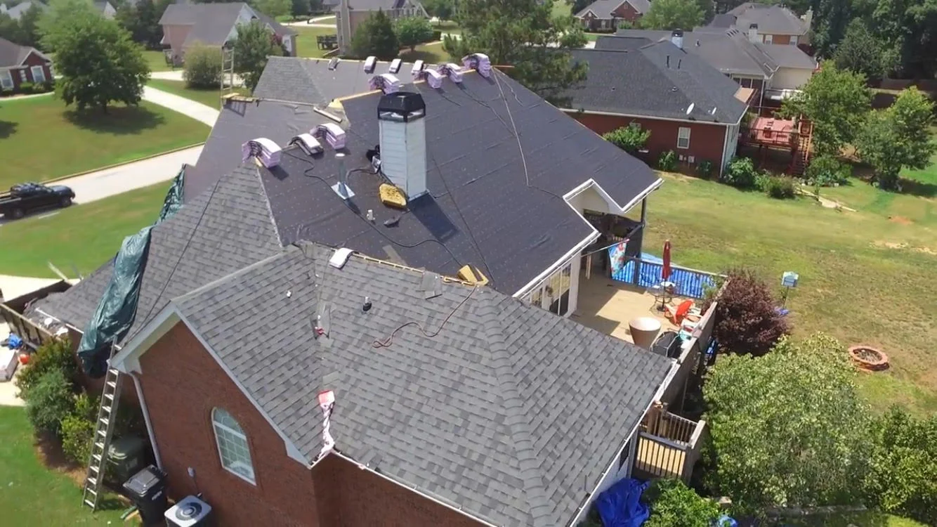 A Diagonal Aerial View of a Shingle Roof Installation in a Suburban Neighborhood