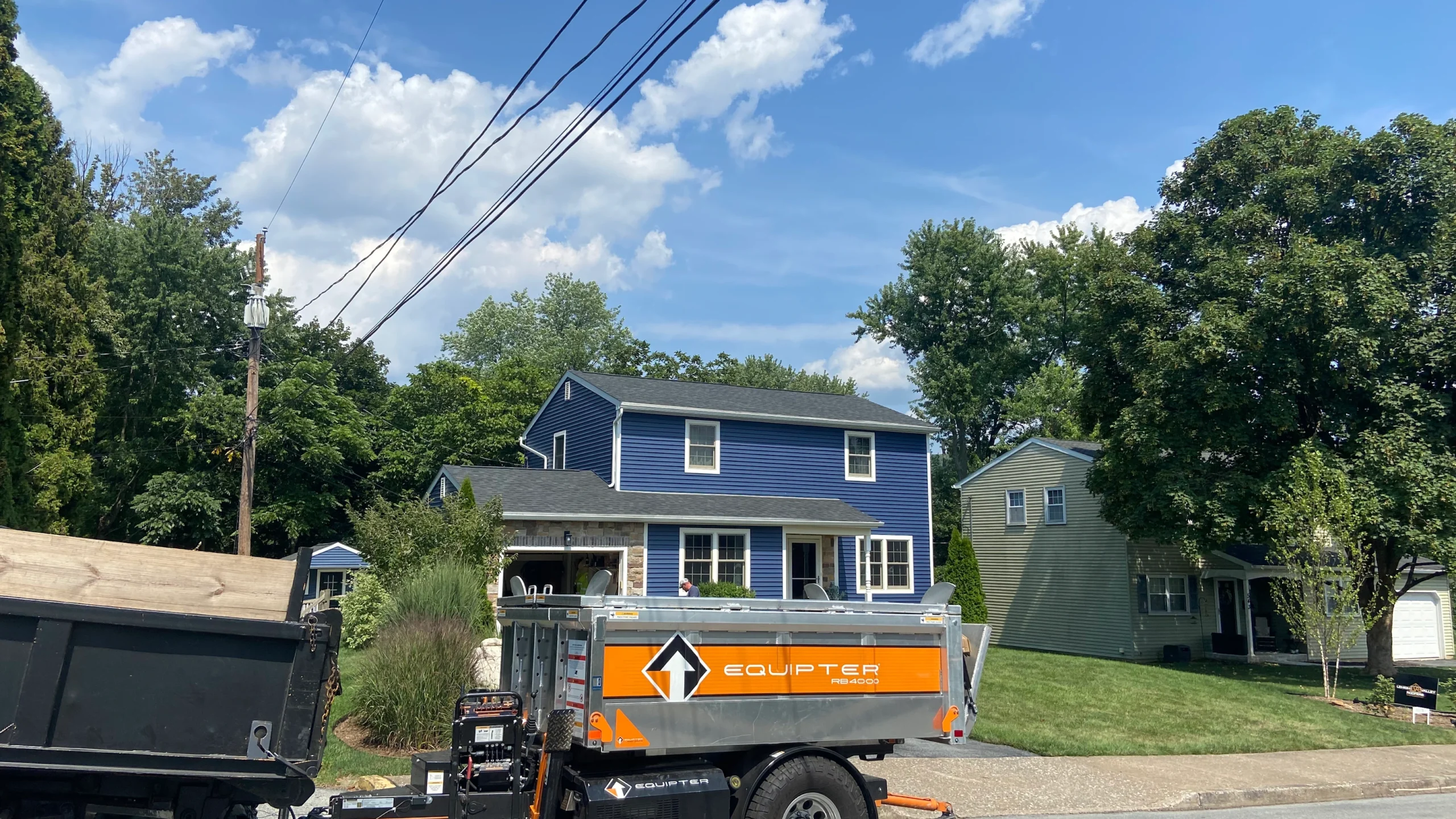 Residential Home with New Shingle Roof and Roofing Equipment Out Front