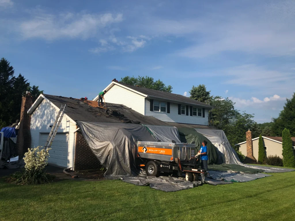 View of House with Roofers Installing Shingle Roof