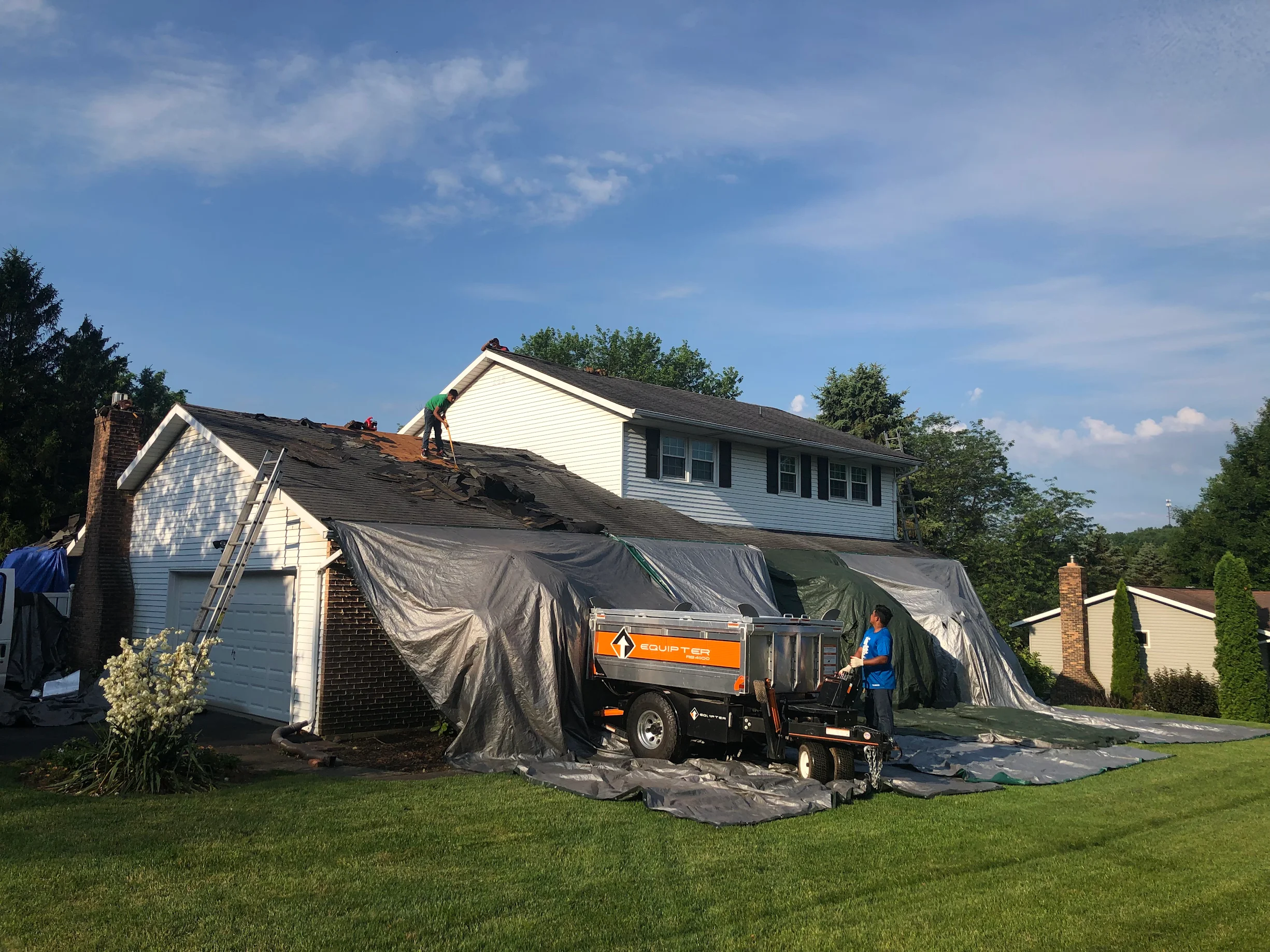 View of House with Roofers Installing Shingle Roof